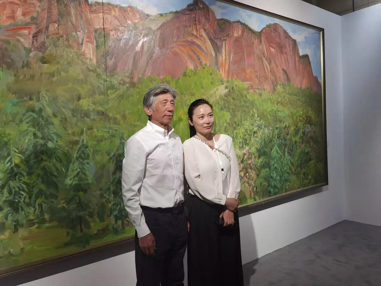 A conversation taking place beside a painting in an exhibition context